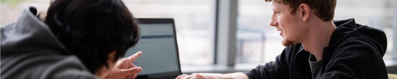 2 students viewing a laptop screen